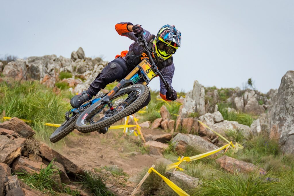 Dynamic shot of a mountain biker navigating rocky terrain in a thrilling race setting.