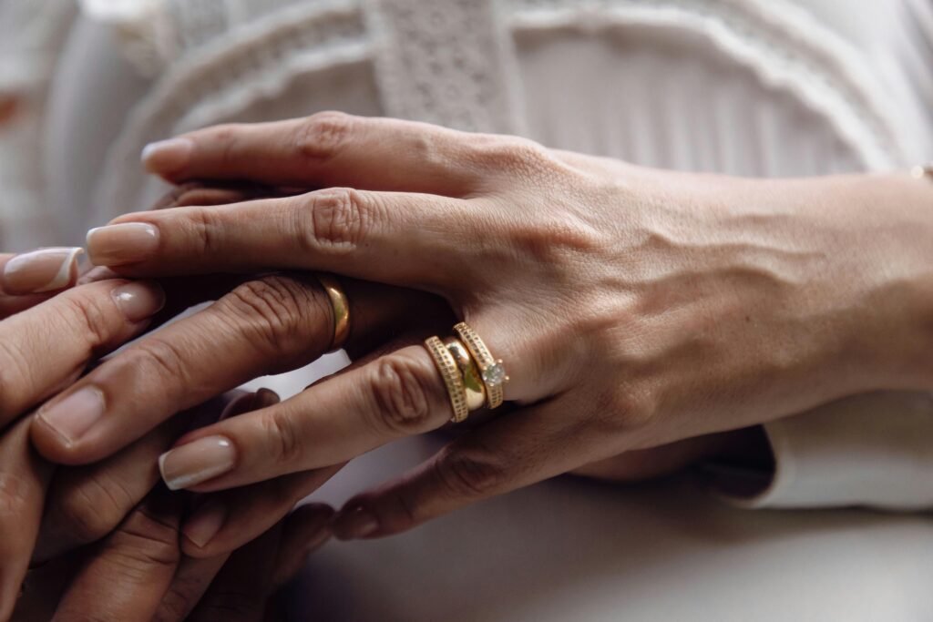 Intimate close-up of a couple holding hands displaying their wedding rings, symbolizing love and unity.